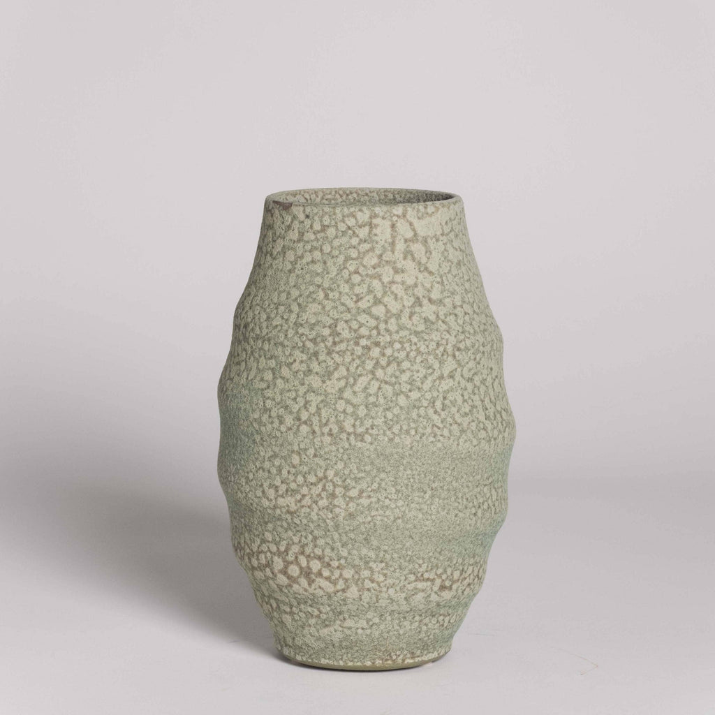 Green textured vase on a light gray background