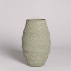 Green textured vase on a light gray background