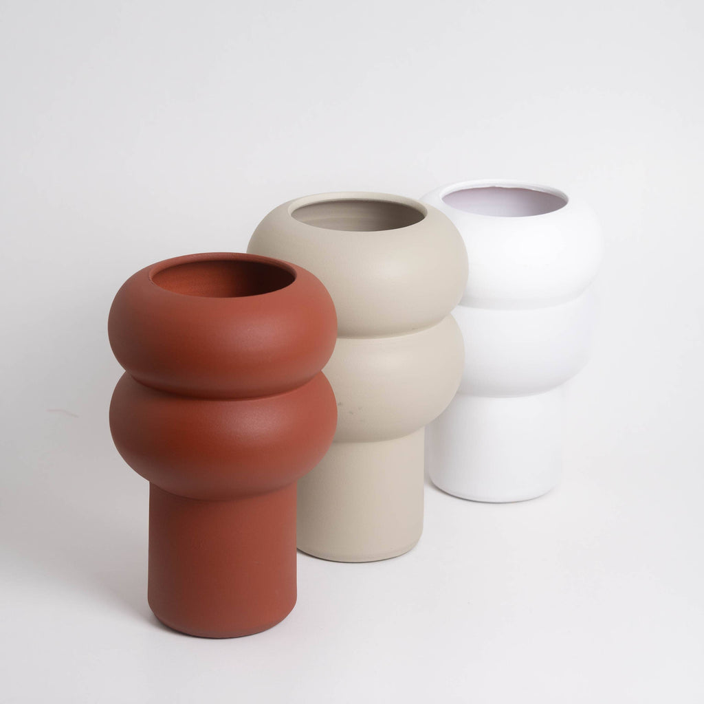 Three ceramic vases in different colors on a white background
