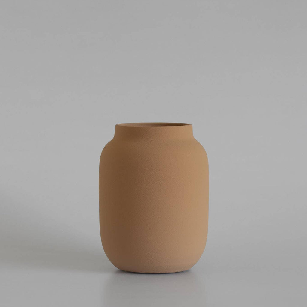 Brown ceramic vase on a light gray background