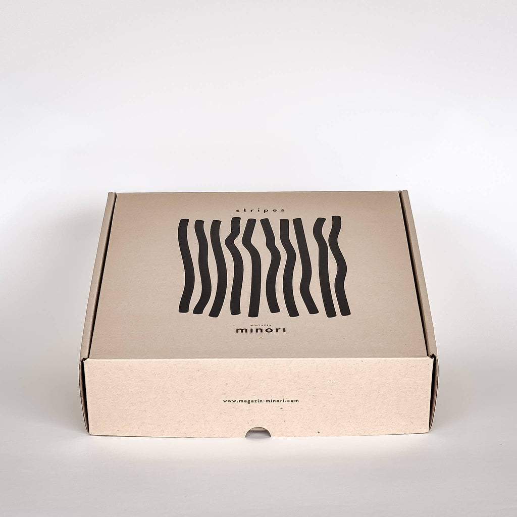 Cardboard box with wavy line design and 'minori' branding on a white background