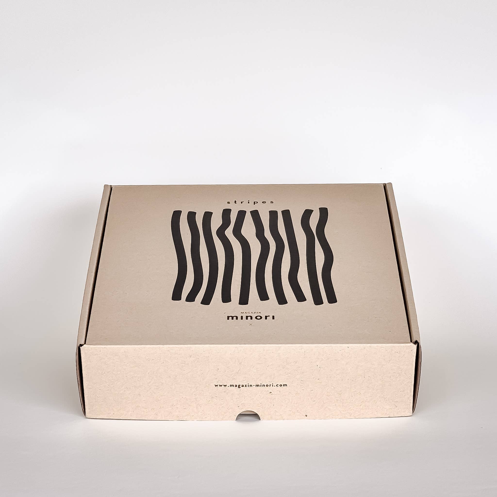Cardboard box with wavy line design and 'minori' branding on a white background