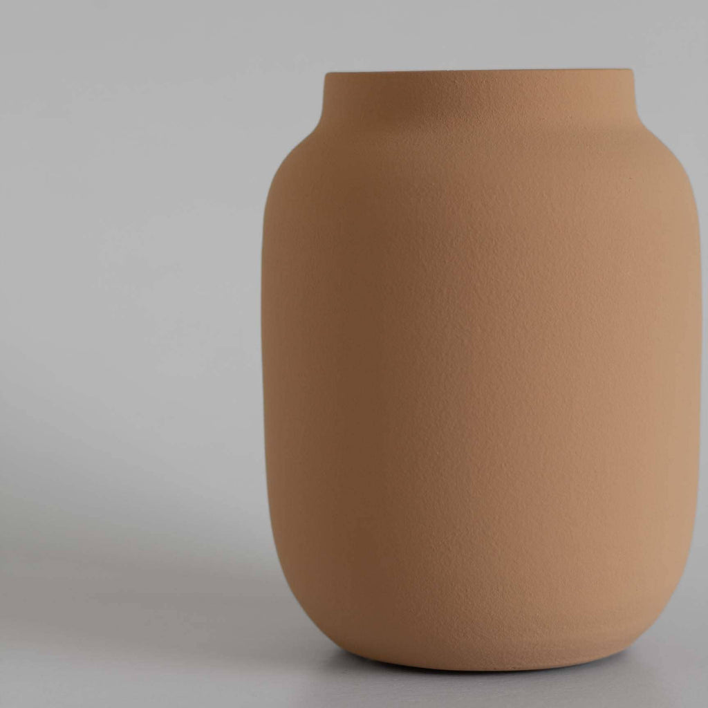 Brown ceramic vase on a light gray background