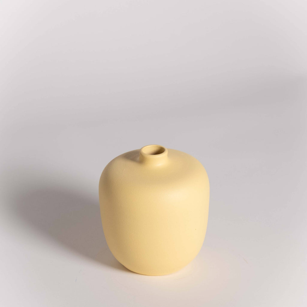 Yellow ceramic vase on a light gray background