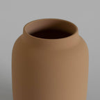 Brown ceramic vase on a gray background
