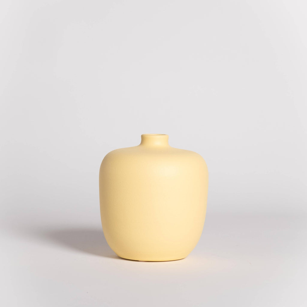 Yellow ceramic vase on a light gray background