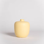 Yellow ceramic vase on a light gray background